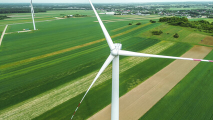 Wind turbine spinning over rural farmland