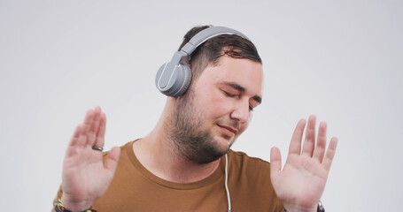 Naklejka premium Headphones, hands and man in studio with music, playlist or gospel radio online for praise and worship. Streaming, holy and person with audio tech for listening to song or album by white background.