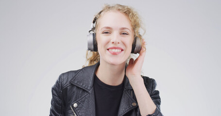 Girl, headphones and happy in studio portrait, digital streaming and album on white background....