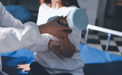 Unrecognizable uses blue hand weight during physical therapy session