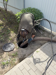 A man is working on a pipe with a hose