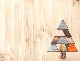 Eco friendly Christmas background. Homemade Christmas tree made of natural biodegradable wooden boards of different color. Ecology, environmental conservation, zero waste concept. Copy space for text