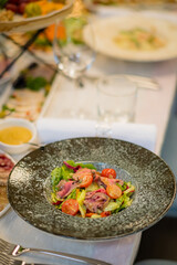Colorful salad with fresh greens and tomatoes is beautifully presented at a chic dining table