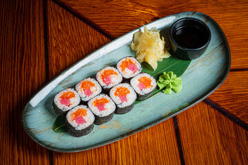 Sushi rolls artfully arranged with wasabi and ginger on a stylish plate, showcasing freshness