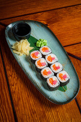 Delightful array of sushi rolls showcases vibrant ingredients and condiments on a rustic table