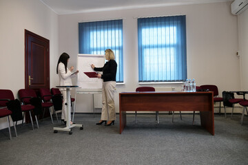 Two business women work in the office to solve problems and sign agreements.