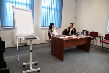 Two business women work in the office to solve problems and sign agreements.