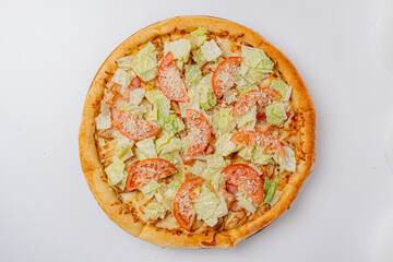 A colorful pizza topped with fresh lettuce, ripe tomatoes, and seasoning promises a delicious bite