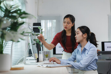 Asian businesswomen working together using desktop computer in office