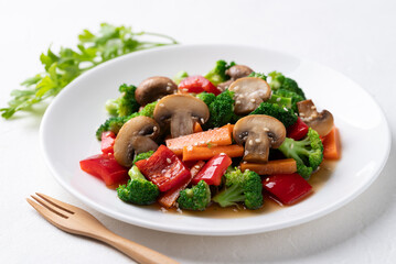 Stir fried vegetables, champignon mushroom, broccoli, bell pepper and carrot with soy sauce, Asian vegetarian food, Healthy eating