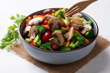 Stir fried vegetables, champignon mushroom, broccoli, bell pepper and carrot with soy sauce, Asian vegetarian food, Healthy eating