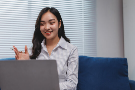 Young asian businesswoman working from home having video call on laptop