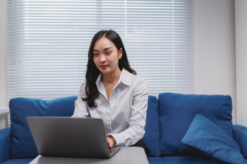 Young asian businesswoman working remotely from home office using laptop