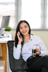 Happy businesswoman talking on the phone during a coffee break