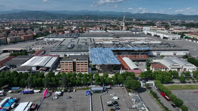 Sweeping aerial drone orbit shot moving left around the grand Re Teodorico entrance of Verona Fairgrounds, showcasing the expansive complex in Veneto, Italy.