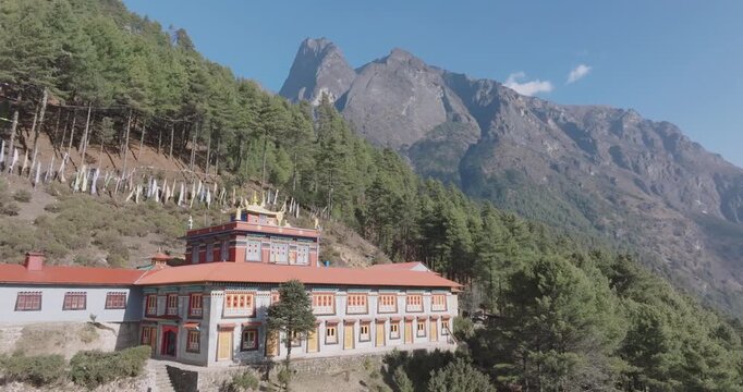 Drone shot of Phakding Monastery at Sagarmatha National Park Everest Region Nepal surrounded by lush forest and morning light in Himalayan landscape