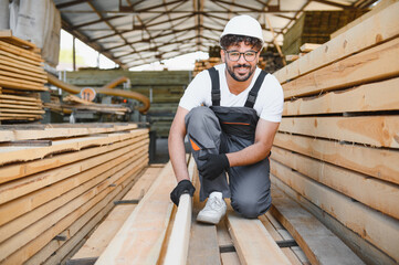Carpenter inspecting lumber in woodworking warehouse