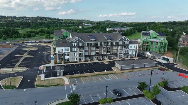 Aerial approaching shot of multi-family apartments condos in suburb of town. Sunny day in summer. Parking area in new developed neighborhood district of Pennsylvania.