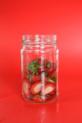 Clear glass jar of strawberry tops for strawberry syrup