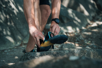 man putting on his climbing shoes outdoors in Stockholm