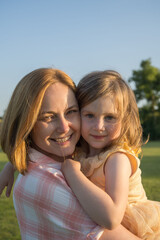 Smiling mum and her toddler daughter, summer time