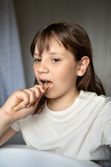 Young girl brushing teeth in front of mirror.