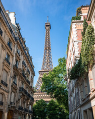 View of Eiffel Tower between buildings on street in Paris, France.