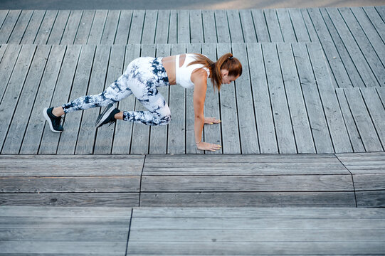 Woman Doing Mountain Climber Exercise on Wooden Steps - Powered by Adobe