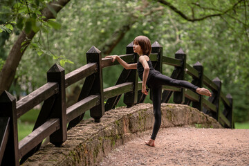Little boy practicing classical choreography on a path in a park.