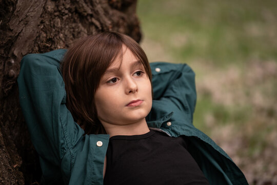 Boy Child resting in the park absorbed in himself.