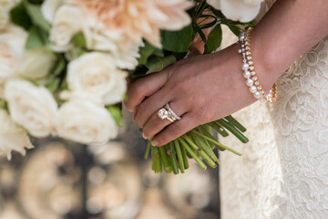 Bride’s Hand Holding Bouquet with Rings and Pearl Bracelet