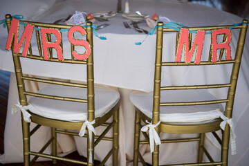 Gold Wedding Chairs with Coral Mr. and Mrs. Glitter Signs