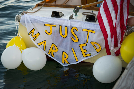 ust Married Boat with Balloons and Flag at Seaside Wedding
