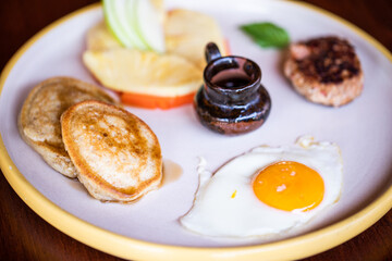Pancakes and Fried Egg with Fruit and Sausage Breakfast
