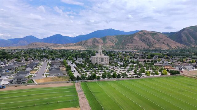 Stunning aerial footage of the remarkable Payson Utah Temple is presented, prominently showcasing its exquisite architecture and the breathtaking surrounding landscape that enhances its beauty