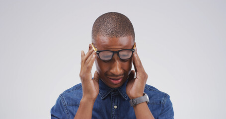 Black man, headache and glasses with fatigue in studio with mockup space, tired or vertigo on white...