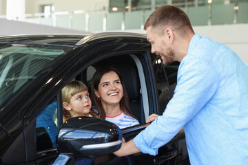 Happy family and new car in salon