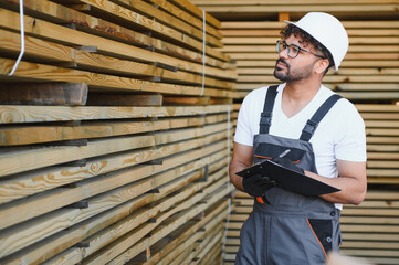 Woodworker inspecting lumber inventory in warehouse
