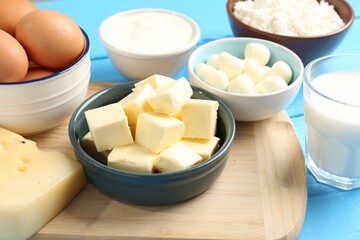 Different dairy products and eggs on light blue wooden table, closeup