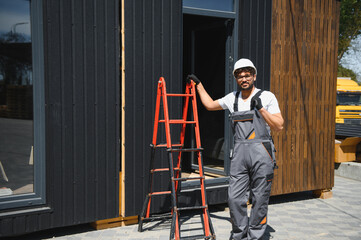 Construction worker supervising modular house transportation by truck