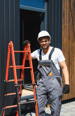 Construction worker leaning on ladder at building site