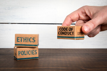 Corporate Ethics and Code of Conduct Concept with Policy Boxes on Wooden Desk