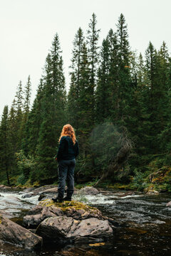 Hiker exploring scandinavian forest and river in hotagen, sweden