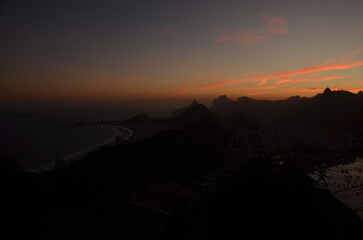 Fototapeta premium Sunset at night on Rio de Janeiro with city lights and the sea and the mountains