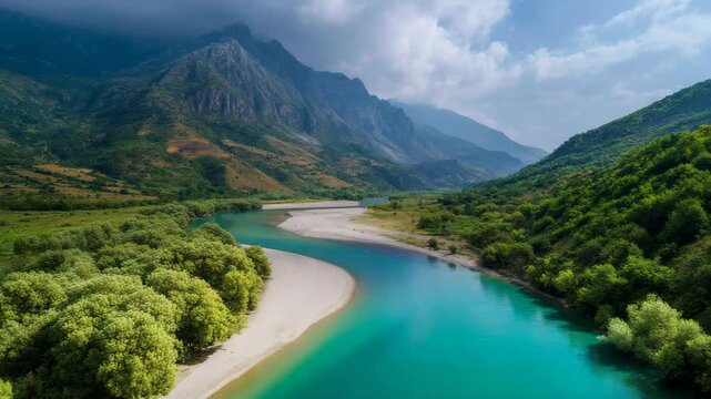 Blue water meandering through rugged terrain under a sky with clouds and patches of blue.