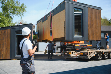 Engineer supervising transportation of modular house by truck