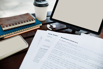close up shot, digital tablet with blank screen and document, smart phone, business contract on wooden table in park, working outside the office concept