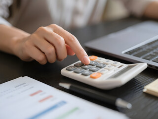 Close up of hand using calculator to calculate home finance, accounting at desk, budget management. Finance, budgeting and tax calculation, monthly expenses