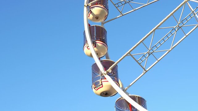 Crown ferris wheel featuring panoramic gondolas against cloudless blue sky during Ekka Royal Queensland Show at Brisbane Showgrounds, close up shot.