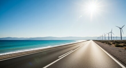 Sunny coastal road with wind turbines under clear blue sky